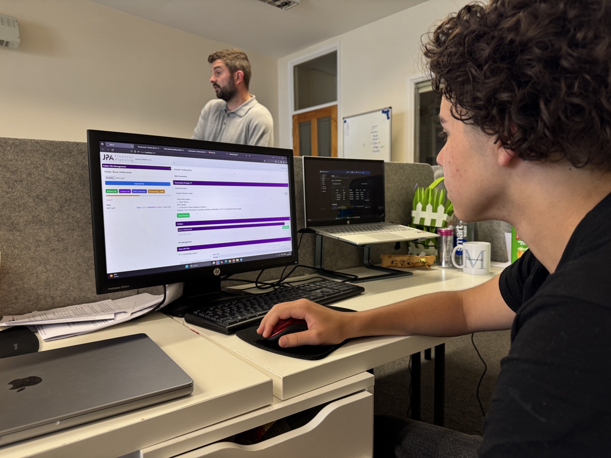 JPA Financial admin staff member working at dual monitor setup using MonAI document processing software in modern UK office